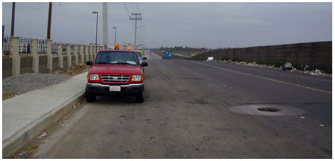 A photo of the IB-1 data collection location, facing west toward the Mexican export compound, with inspection vehicles in the foreground.