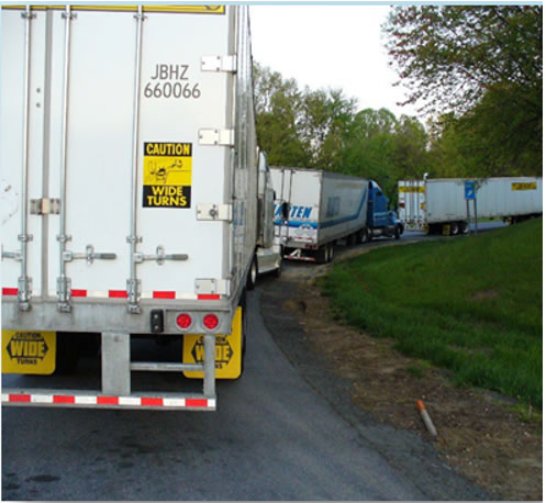 Line of freight trucks on the road going around a bend.