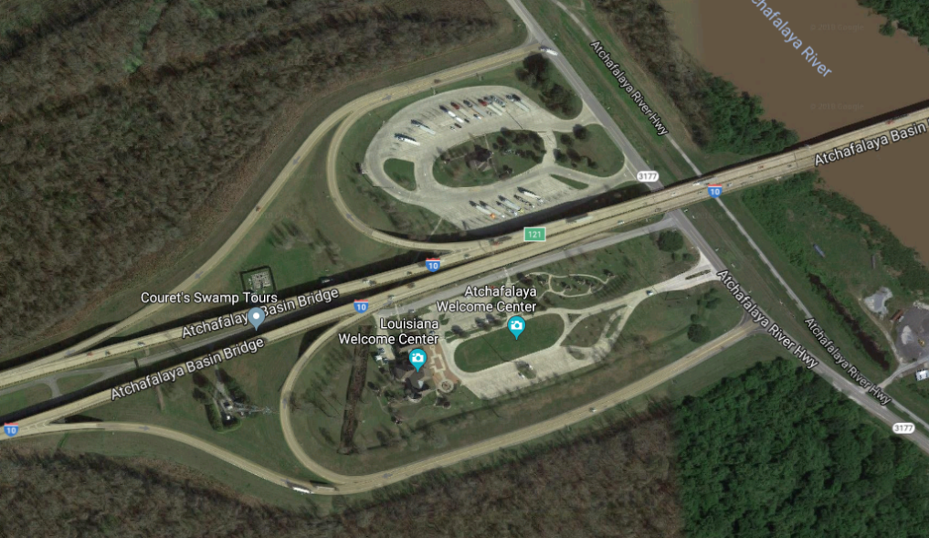 Aerial view of highway truck parking facilities within two cloverleaf areas of a highway interchange at the Butte las Rose Rest area.