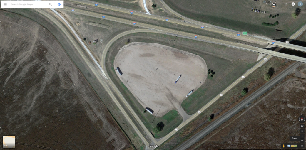 Aerial view of a highway truck parking facility inside a half cloverleaf exchange at Big Springs, Nebraska.