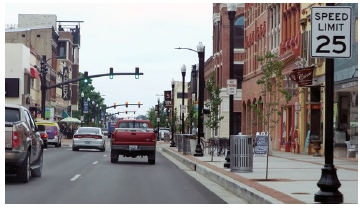 A series of signalized intersections in a downtown area from the perspective of a vehicle driving on the corridor.