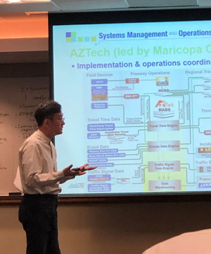 A man standing in front of a screen giving a presentation.