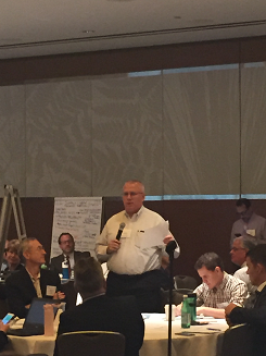 Image of Texas Department of Transportation, Transportation Program Officer, Brian Barth, speaking to a group of participants siting around tables.