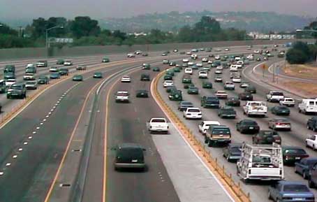 photo showing two express lanes in each direction separated by a concrete barrier. The express lanes are located in the median of the freeway, separated from the general purpose lanes by channelizing devices