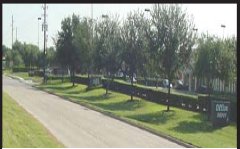 Photograph of a frontage road with a landscaped median separating it from a highway.