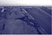 Photo. End of a road approaching a destroyed bridge.