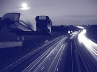 Photo. East-bound and west-bound traffic on an interstate and traffic cameras overlooking the highway.