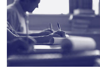 Photograph of meeting attendees taking notes.