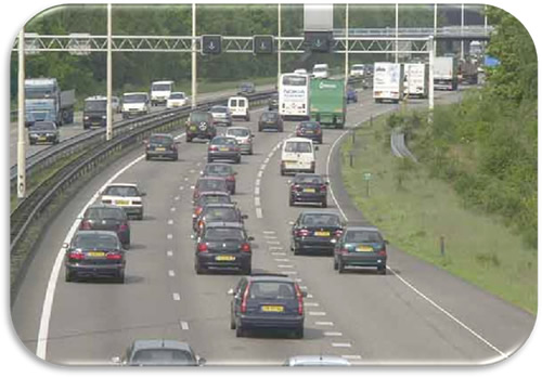 Figure 24. Photo. Temporary Right Shoulder Use—The Netherlands. Photo of an urban freeway in The Netherlands where the right shoulder is open to traffic. Lane control signals indicate that the right shoulder is open.