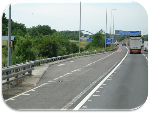 Figure 6. Photo. Shoulder Use with Emergency Refuge Area-England. Photo illustrating an emergency refuge area with an emergency call box to the left of the left shoulder.