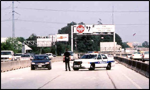 Photo of a law officer standing next to his vehicle conducting a visual check for HOT enforcement.