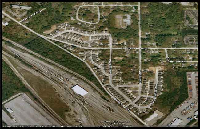 Figure 2.4 is an aerial photograph showing new residential development adjacent to a container yard and rail terminal.