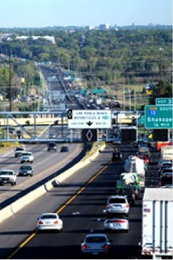 Photo of variable message signs installed on horizontal poles suspended above lanes of traffic.