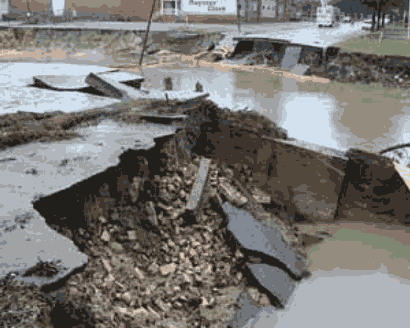 Picture of a roadway which has been broken up by a flood.