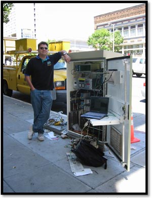 Photo - Photograph of a traffic controller cabinet open along a roadway.