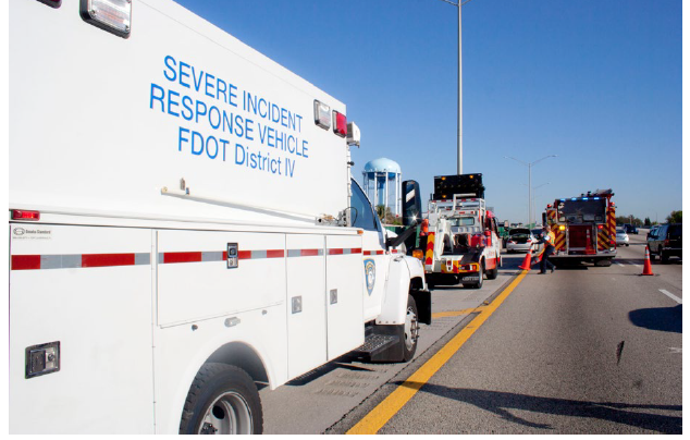 Responders using a wide shoulder for their vehicles as they respond to a highway incident.