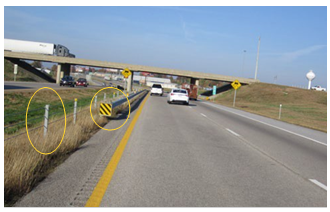 Roadside with a cable median barrier and a guardrail with a retroreflective impact absorber placed on the leading end of the rail to alert traffic to the rail's presence.