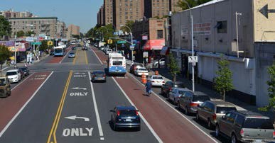 Picture of an arterial street with exclusive bus lane to the right with a different color pavement.