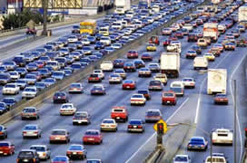 This is a photograph of vehicles entering from a ramp meter onto a heavily travelled mainline.