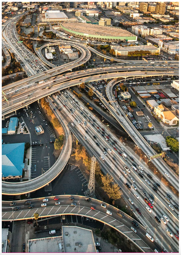 Overhead view of an urban corridor with a mix of vehicle traffic, transit services, bicyclists, and pedestrians.