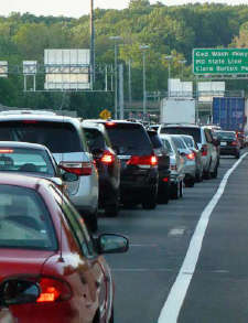 A long line of stopped cars in advance of a freeway exit.