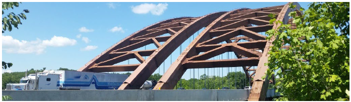 A truck carrying freight crossing a bridge.