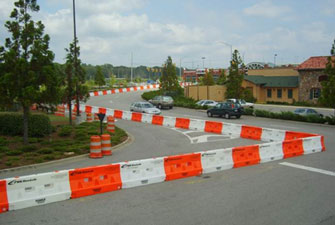 This photo shows longitudinal channelizing devices arranged to redirect cars—forcing cars to make a 90 degree right turn in an intersection instead of using a curved right-turn lane.