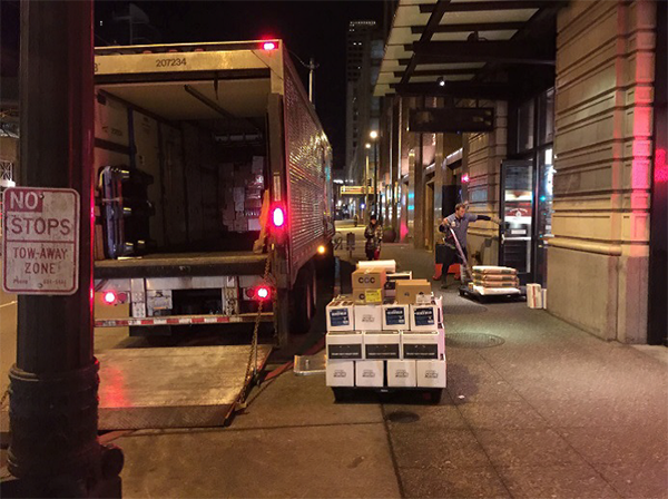 photo of a man delivering pallets of boxes to a NYC store