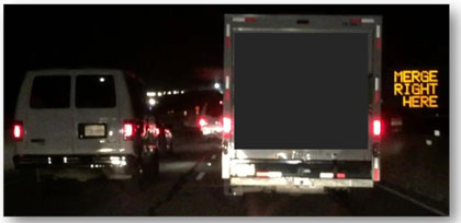 Photograph of the first phase of a DMS indicating dynamic merge control.  The DMS on the right hand side reads 'MERGE RIGHT HERE.'
