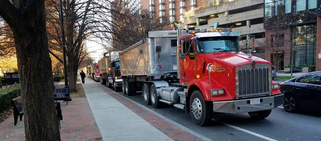 photo of construction trucks lined up on a city street