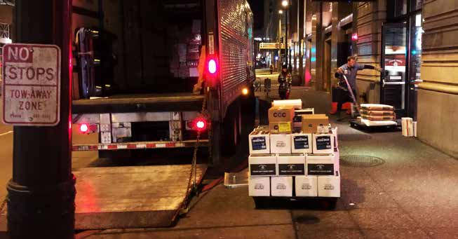 photo of pallets of supplies being delivered to a city restaurant at night