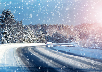 Car tire tracks on winter road covered with snow.