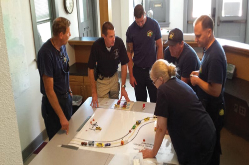 group of people in discussion over a model traffic incident