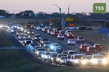 Photograph of evening traffic traveling through a traffic signal identifying with the Traffic Signal System Management CMF. (Credit: TTI Communications)