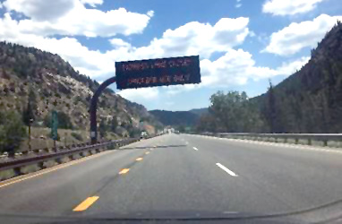 Photo shows a road with a dashed yellow line to divide the left shoulder from the rest of the road, with white dashed lines for the lane.