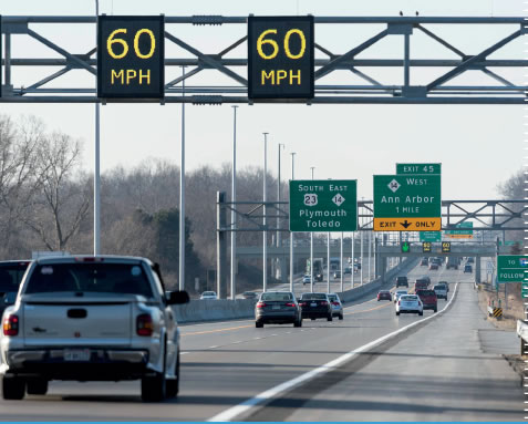 Insterstate highway with electronic overhead speed limit signs.