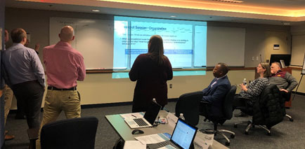 A group of people looking at presentation being projected onto a screen.