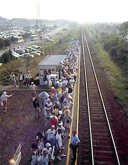 a photo showing a group of event patrons standing on a commuter rail station platform