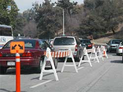 photo showing several vehicles traversing two lanes, operating in the same direction, separated by Type 1 barricades