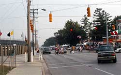 photo showing an intersection with two paved crosswalks, crossing a multi-lane road, adjacent at a venue gate