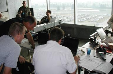 three traffic management team personnel looking at a laptop computer screen