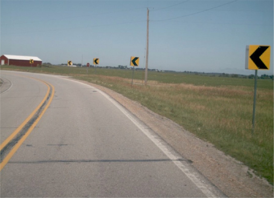 photo of chevron sign to the right of a roadway