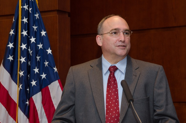 Photograph of Greg Nadeau at the dais, addressing summit attendees