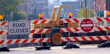 barricades in front of work zone with signs stating "road closed" and "do not enter"