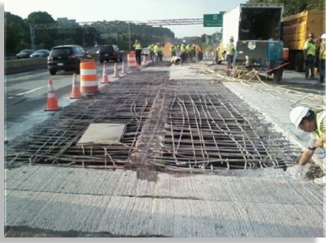 Workmen working on the exposed bridge deck.