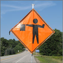 Photo of a flagger symbol warning sign.