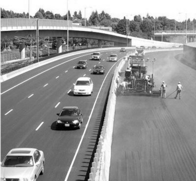 Figure 3 shows an asphalt paver and crew laying hot mix asphalt on a fully closed section of westbound I-84.  Traffic flows normally on eastbound I-84.