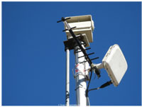 A photograph shows sensor and transmitter equipment on a small tower.