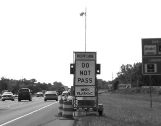 This figure is similar to the front cover photo. It shows one trailer activated with the lights flashing. Two lights are on each side of the signs, alternating flashes from top to bottom.